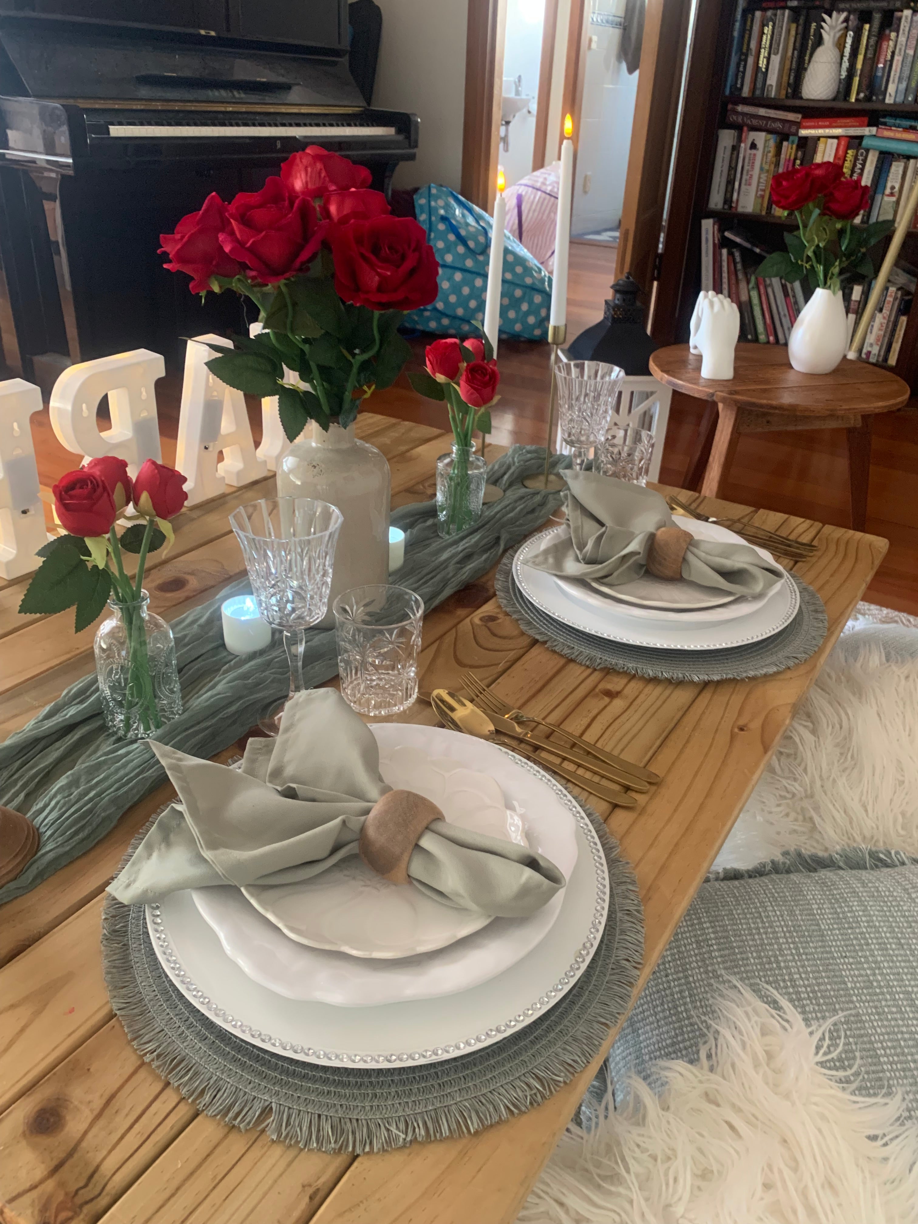 Sage themed proposal picnic table setting with red roses Wellington events