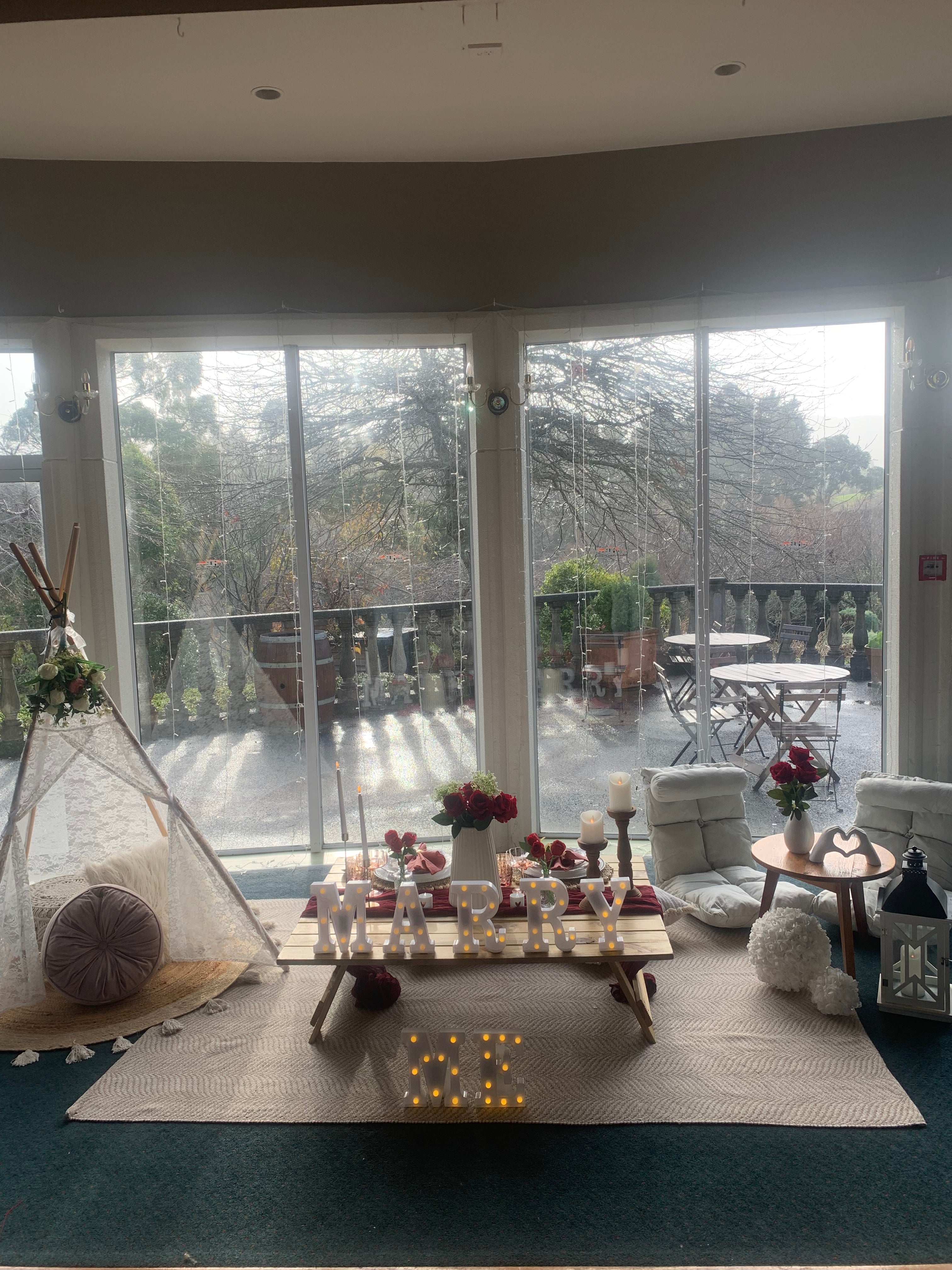 An indoor marry me proposal picnic setup at Aston Norwood Gardens on a cold rainy day in Wellington